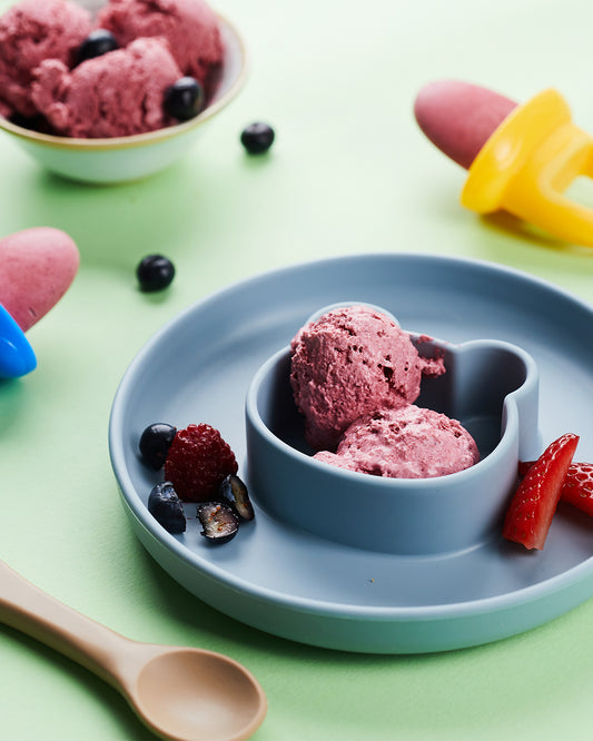 Baby berry nice cream, purple ice cream in a weaning bowl with fresh fruit