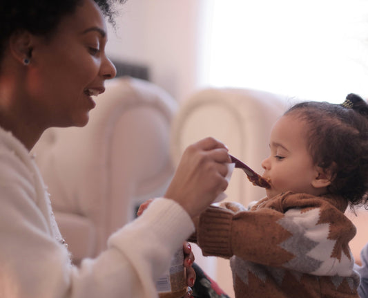 A mother feeding her weaning baby