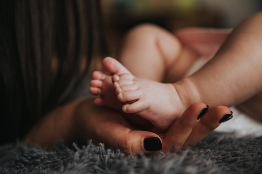 A new mother holding her baby’s feet