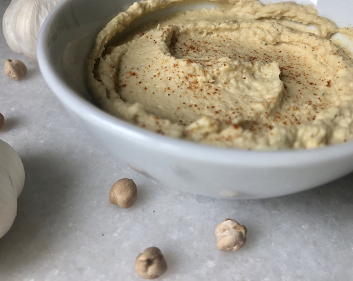 Bowl of hummus next to chickpeas