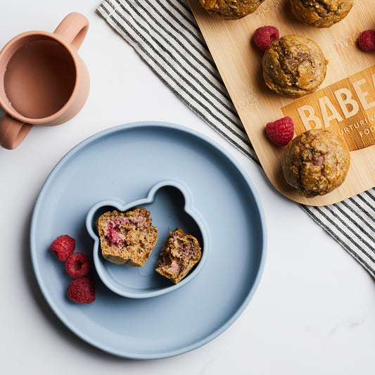 Courgette and Berry muffins on a silicone bear weaning plate with raspberries