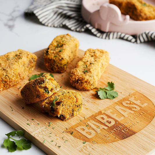 Vegetable croquettes oven baked with breadcrumbs on a wooden chopping board