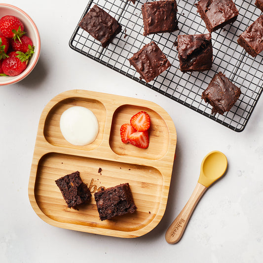 Sweet potato brownies served on a weaning plate with strawberries and cream or yoghurt