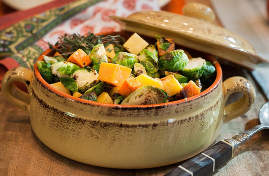 A dish filled with brussels sprouts, butternut squash and apple